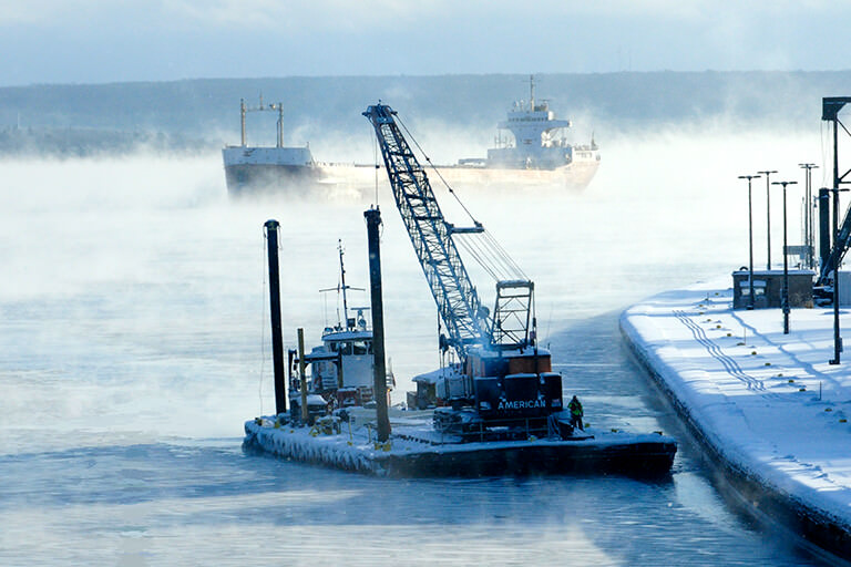 Tug pulling a barge in the winter.